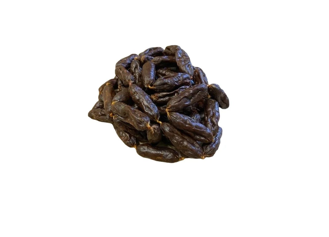 Pile of natural premium British pork mini sausages dog chews high protein low fat air dried treats for dental health and satisfying chewing.