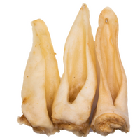 Three natural goat ears dog chews standing together high protein low fat air dried treats for teeth and gums and chewing enrichment.