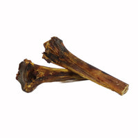 Two natural ostrich metatarsus bones stacked high protein low fat dog chews long lasting treats for teeth and gums.